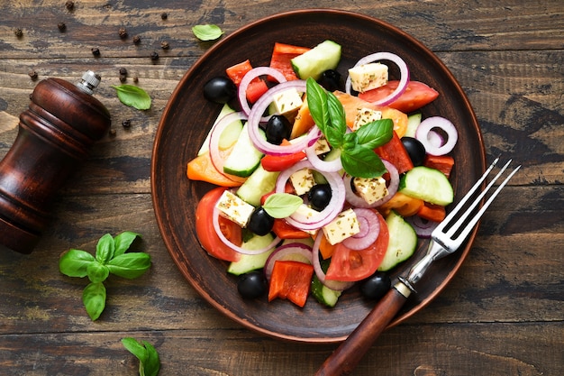 Classic Greek salad with feta on a wooden background.