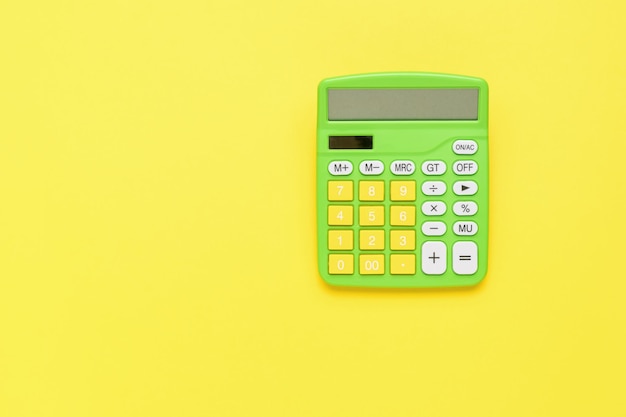 Classic green and yellow calculator on a yellow background The concept of business and education