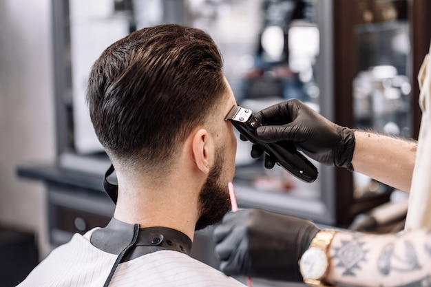 理髪店での古典的なヘアカット。理髪店でのカーブヘアスタイリングとヘアヘルスケア。男性用