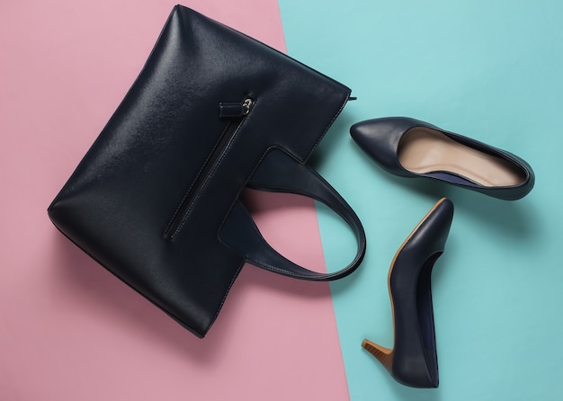 Classic high heel shoes, leather bag on a blue-pink pastel