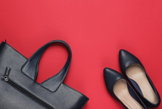 Classic high heel shoes, leather bag on red