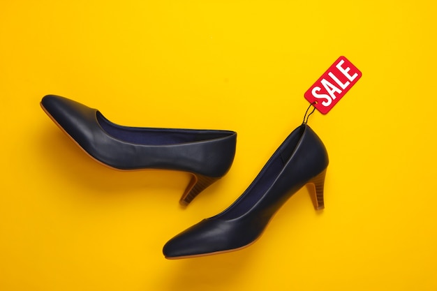 Classic high heel shoes with a red sale tag on a yellow. Big Sale, discounts