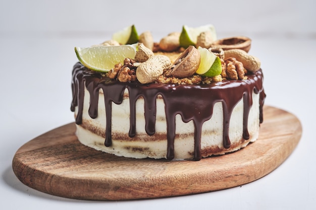 Classic homemade honey cake. A birthday cake with honey, chocolate, nuts and nut butter. Dessert on a wooden board.