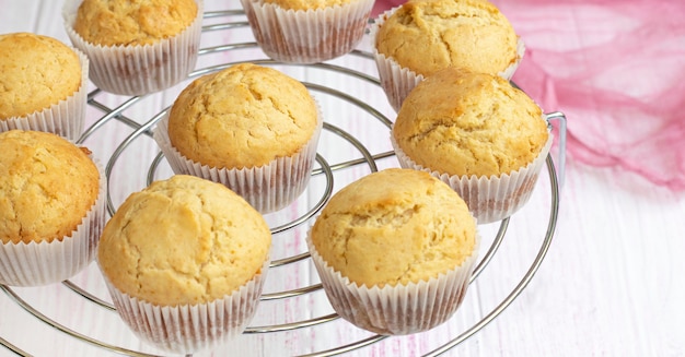 classic homemade muffins are cooled on a wire rack to cool Fresh vanilla cupcakes close up Vanilla