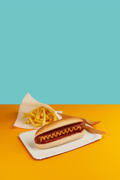 Photo classic hot dog with french fries on orange table restaurant me