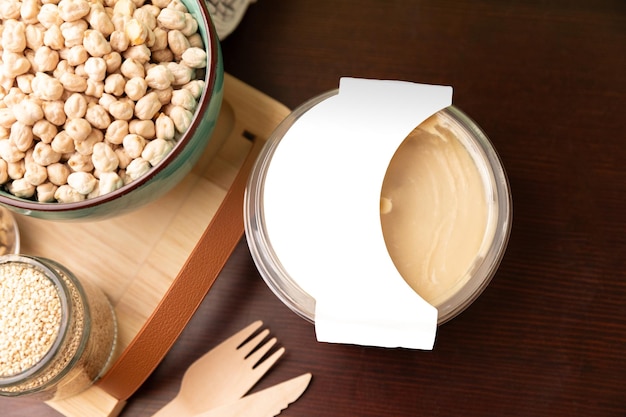 Photo classic hummus packaging mockup on wooden table top view