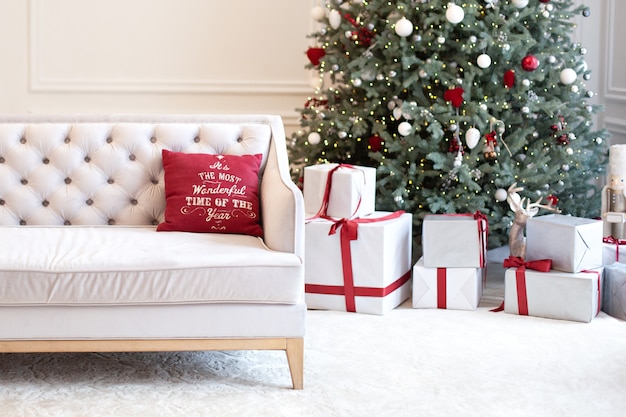 ソファで飾られたシックなクリスマスツリーとギフトを備えたクラシックなインテリアのリビングルーム