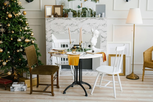 Classic interior of the vintage dining room with a marble fireplace round table and various chairs