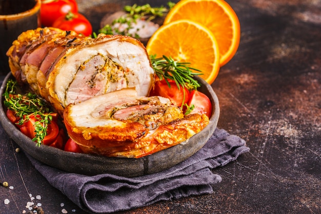 Classic Italian baked porchetta with oranges, copy space. 