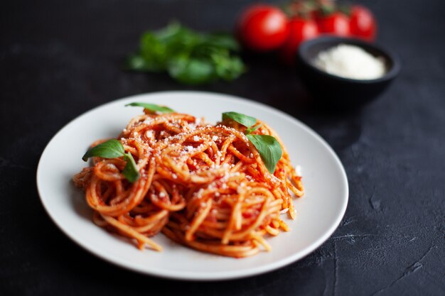 Photo classic italian pasta with tomato sauce, cheese parmesan and basil on plate