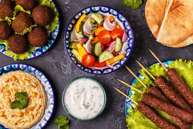 Foto spiedini classici, falafel e hummus nei piatti