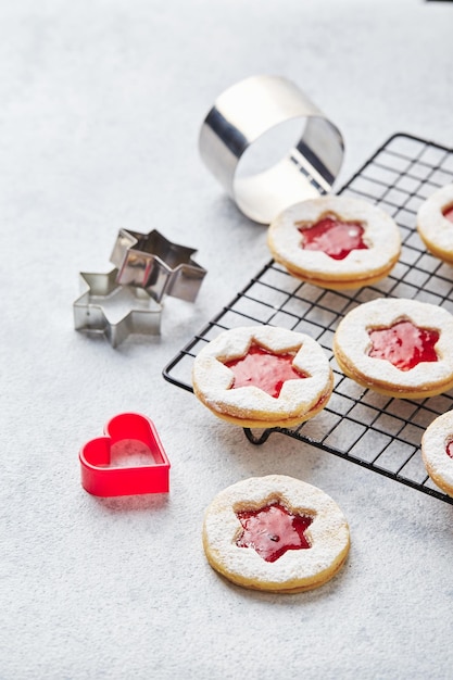 Foto biscotti di natale linzer classici con marmellata di lamponi o fragole su sfondo chiaro