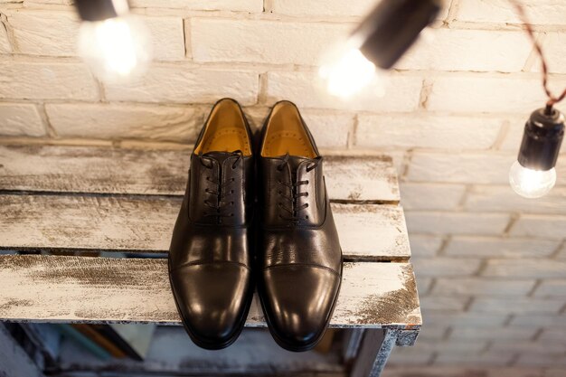 Классические мужские кожаные туфли на деревянном фоне Стильные мужские аксессуары