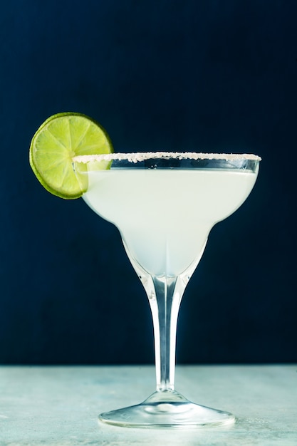 Classic margarita cocktail on the table with bar accessories.