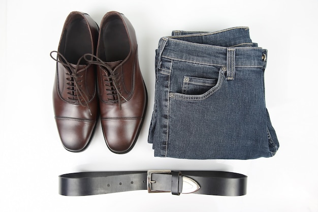 Classic men's brown shoes, belt and clothes on white space