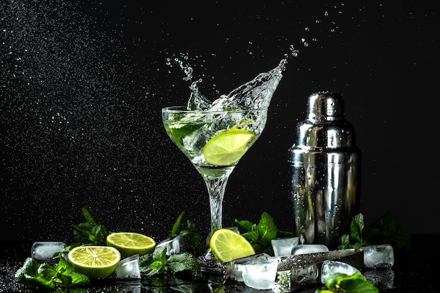 Classic Mojito Cocktail Ingredients lime mint sugar ice with splashes on dark background Freeze motion drops in liquid splash Cuban national drink