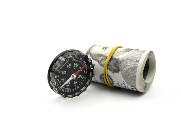Classic navigation compass and bundle of money roll of dollars isolated on white background
