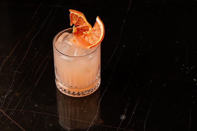 Classic orange cocktail glass on glass table in night club\
restaurant alcohol cocktail drink garnish with orange chips closeup\
modern alcoholic beverage