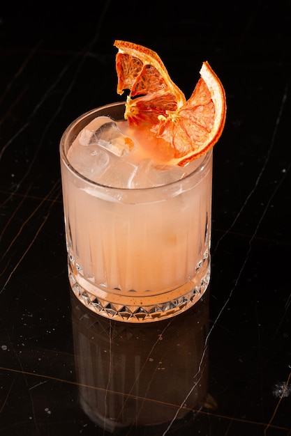 Classic orange cocktail glass on glass table in night club\
restaurant alcohol cocktail drink garnish with orange chips closeup\
modern alcoholic beverage