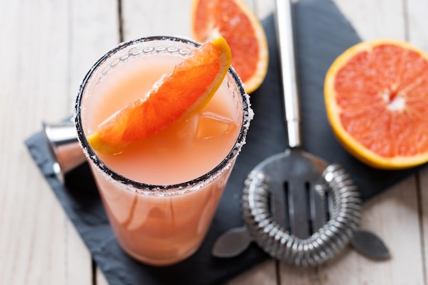 Classic paloma cocktail on white wooden table