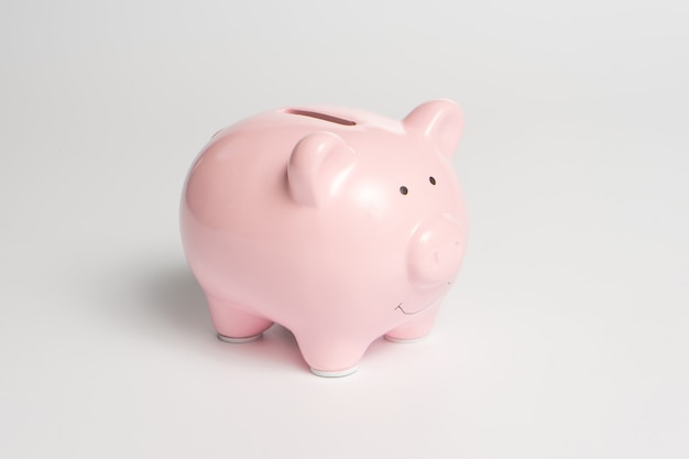 Classic pink piggy bank for money on a white background