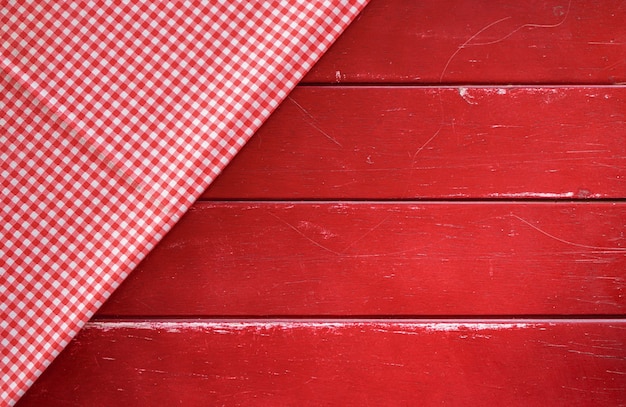 Photo classic pink plaid fabric or tablecloth on old red wood table with copy space