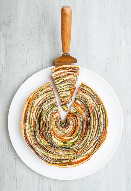 Photo classic ratatouille pie on a light gray table.