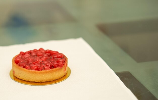 Classic red berry curd tart on glod plate on table with copy space