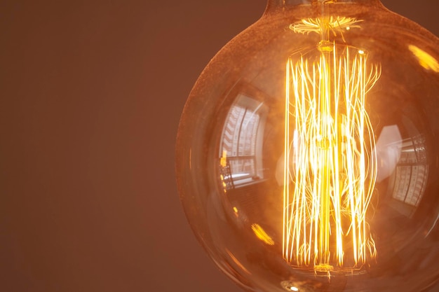 Classic retro incandescent edison light bulb close up of the glowing filament