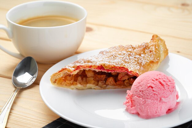 Classic shtrudel dessert with ice cream on white plate