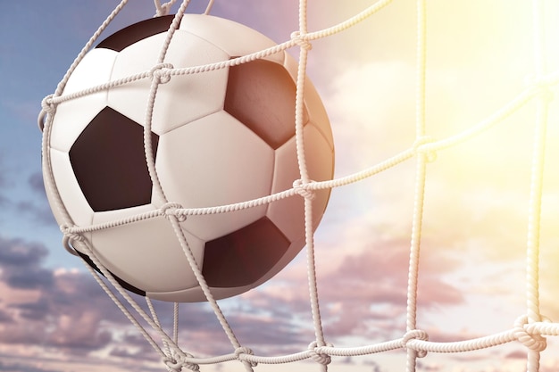 Classic soccer ball in the net on the sky background