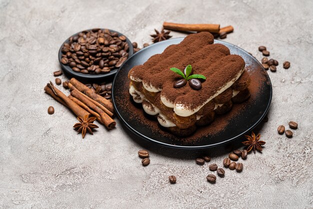 Classic tiramisu dessert on ceramic plate on concrete background