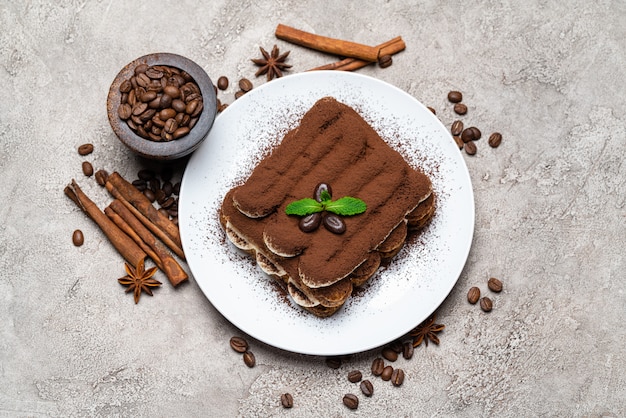 Classic tiramisu dessert on ceramic plate on concrete table