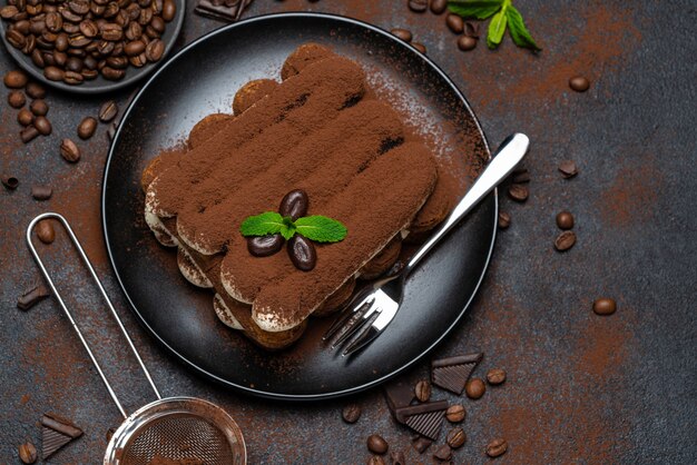 Classic tiramisu dessert on ceramic plate on concrete 