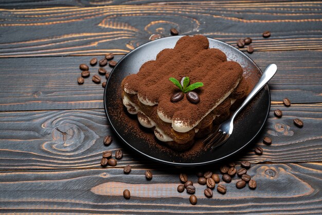 Classic tiramisu dessert on ceramic plate on wooden 