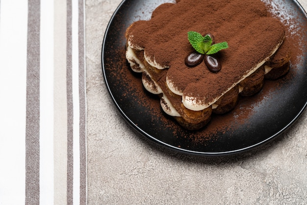 Foto classico dessert tiramisù su un piatto di ceramica