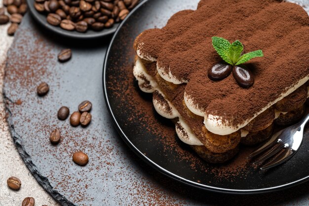 Classico dessert tiramisù su un piatto di ceramica