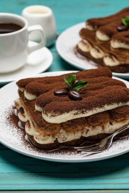 Classic tiramisu dessert, a cup of coffee and milk