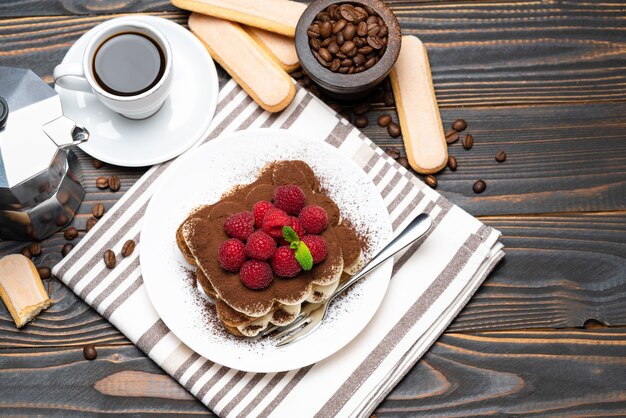 Classic tiramisu dessert with raspberries and a cup of espresso