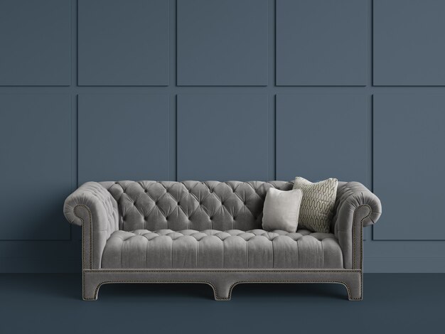 Классический тафтинговый диван в пустой комнате с серыми стенами. Минимальная концепция