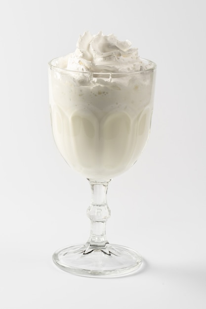 Classic vanilla milk protein shake, with whipped cream on a white plate.