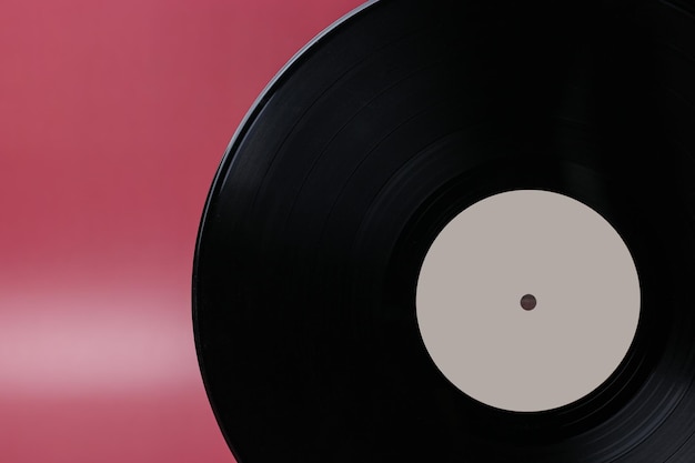 Classic vinyl record closeup on a red burgundy background outdated data storage music