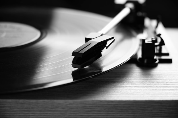 Photo classic vinyl record player closeup with contoured daylight from window in black and white photo