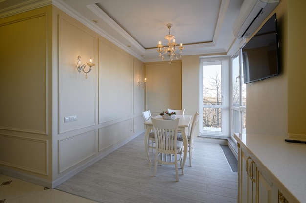 Classic white and beige large kitchen with dining table in studio apartment