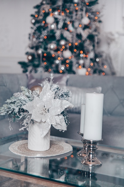 Interno classico di natale bianco con elementi moderni e albero di natale decorato.