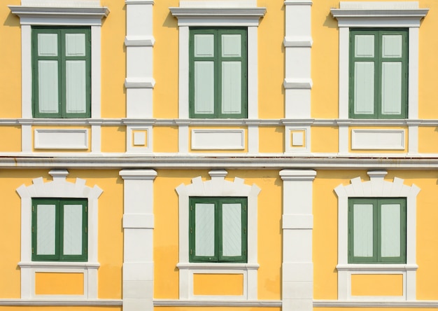 Classic wood window at the yellow concrete building