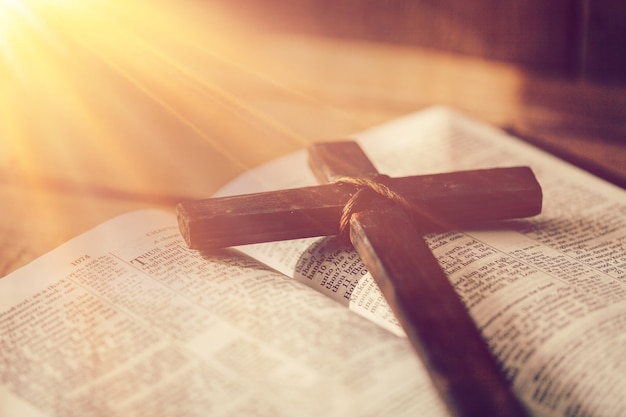 Classic wooden christian cross on the open book