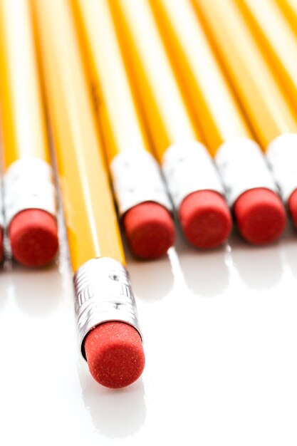 Classic yellow pencils with red eraser on a white background.