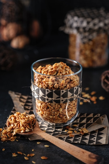 Granola classica in un bicchiere su una parete scura