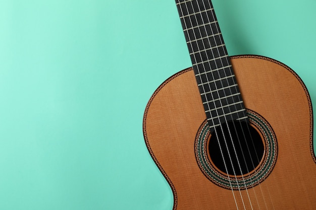 Classical guitar on mint background, space for text